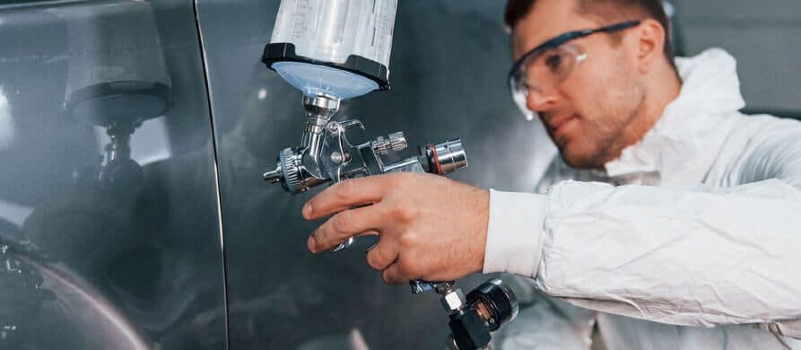 Tehnician cu pistol de vopsit în timpul unei vopsiri